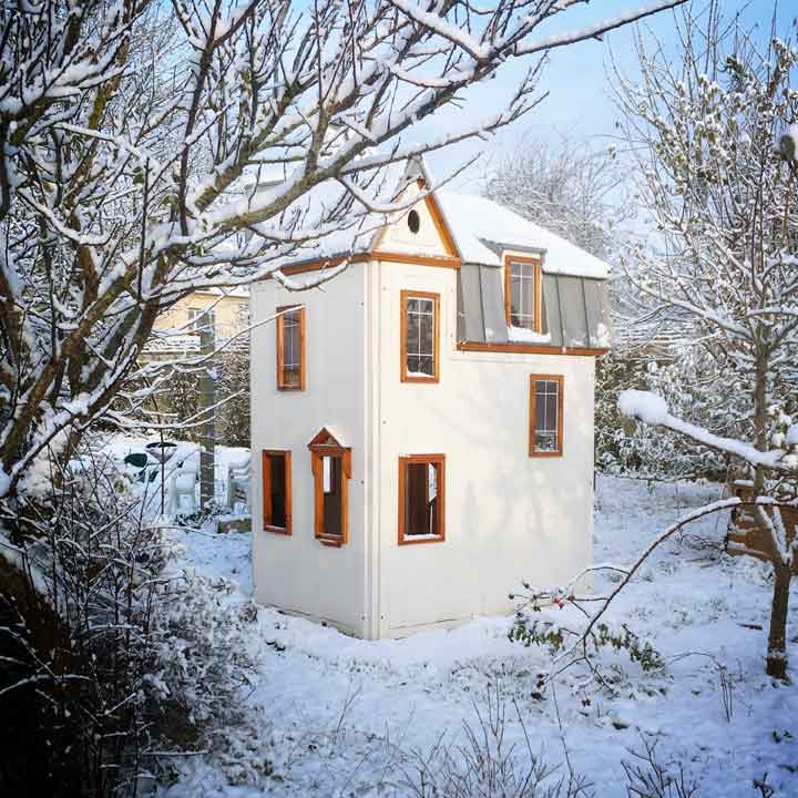 Maisonnette dans un jardin sous la neige